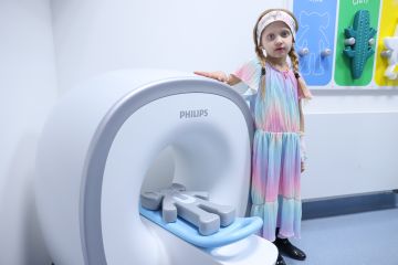 Malá pacientka představuje model Kitten Scanner, foto_FNMH