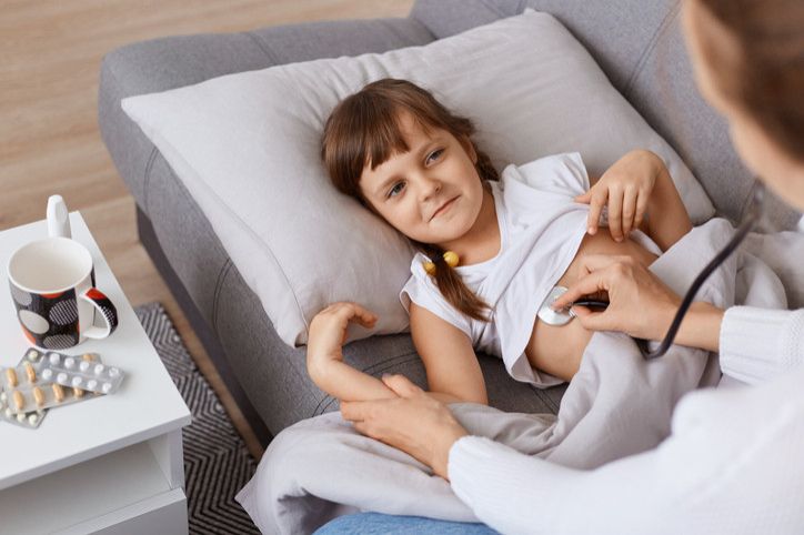 Unrecognizable pediatrician holding stethoscope exam child girl patient at home, doctor checking heart lungs of kid do pediatric checkup while little child catching cold2e00