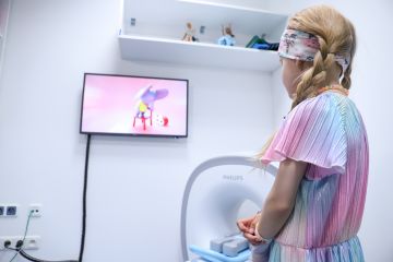 Unikátní koncept Philips Pediatric Coaching. Malá pacientka sleduje edukační video pro děti, které se chystají na vyšetření. Svůj hlas animovaným postavičkám připravujícím děti na vyšetření magnetickou rezonancí propůjčila MUDr. Marie Bartoníčková. Foto: FNMH